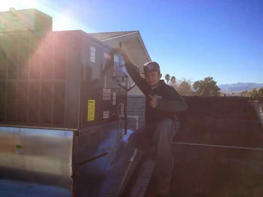 HVAC technician performing HVAC Inspection on a rooftop unit in Moorhead