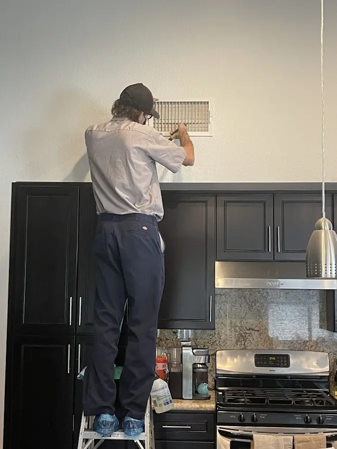 Technician inspecting an air vent during HVAC service in Moorhead